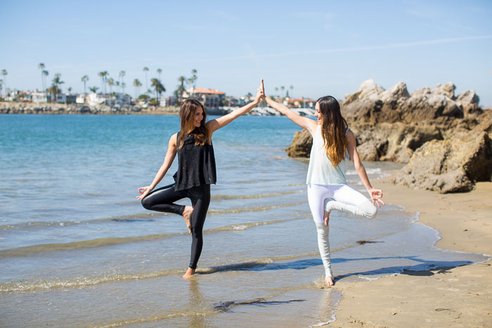 girls doing yoga on the beach